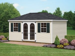 Hip Roof Shed with beige vinyl siding, windows with black shutters, a black asphalt roof, white trim, and a set of double doors with decorative windows.