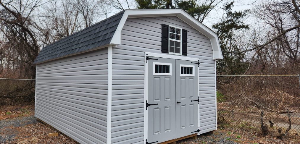 dutch barn shed with double doors with windows, and a window with shutters above the door